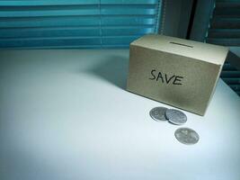 A box of savings and coins stacked on a table, for background purpose photo