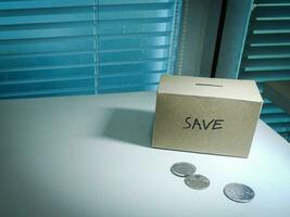 A box of savings and coins stacked on a table, for background purpose photo