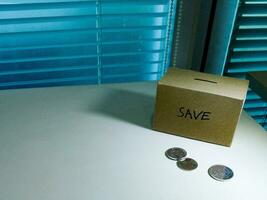 A box of savings and coins stacked on a table, for background purpose photo