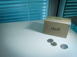 A box of savings and coins stacked on a table, for background purpose photo