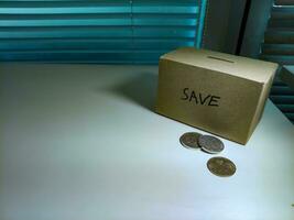 A box of savings and coins stacked on a table, for background purpose photo