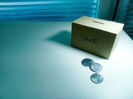 A box of savings and coins stacked on a table, for background purpose photo