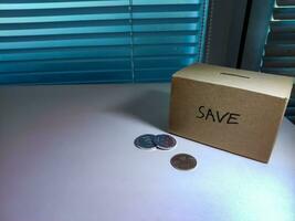 A box of savings and coins stacked on a table, for background purpose photo