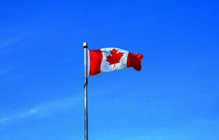 el bandera de Canadá en azul cielo antecedentes cerca arriba. foto