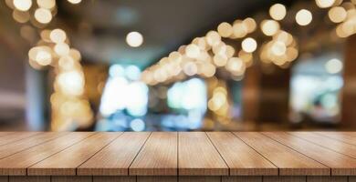 Empty wooden table top with lights bokeh on blur restaurant background. photo