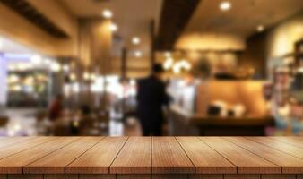 Empty wooden table top with lights bokeh on blur restaurant background. photo