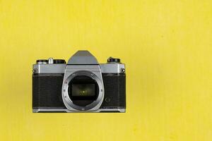 Vintage Film Camera isolated on yellow background photo