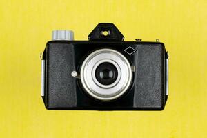 Vintage Film Camera isolated on yellow background photo