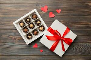 Delicious chocolate pralines in red box for Valentine's Day. Heart shaped box of chocolates top view with copy space photo