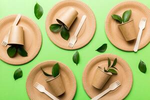 set of empty reusable disposable eco-friendly plates, cups, utensils on light white colored table background. top view. Biodegradable craft dishes. Recycling concept. Close-up photo