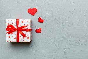 Valentine day composition red  gift box with bow and heart. Christmas present. View from above. Space for text. Holday greeting card photo