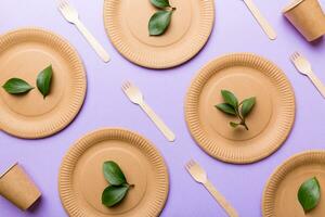 set of empty reusable disposable eco-friendly plates, cups, utensils on light white colored table background. top view. Biodegradable craft dishes. Recycling concept. Close-up photo