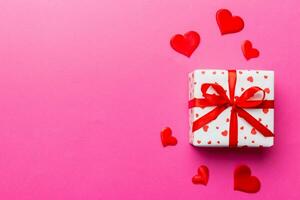 Valentine day composition red  gift box with bow and heart. Christmas present. View from above. Space for text. Holday greeting card photo