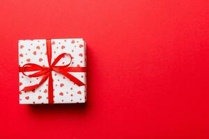 Valentine day composition red  gift box with bow and heart. Christmas present. View from above. Space for text. Holday greeting card photo