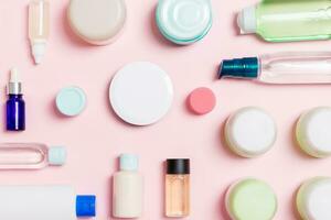 Group of plastic bodycare bottle Flat lay composition with cosmetic products on pink background empty space for you design. Set of White Cosmetic containers, top view with copy space photo