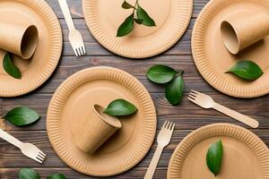 set of empty reusable disposable eco-friendly plates, cups, utensils on light white colored table background. top view. Biodegradable craft dishes. Recycling concept. Close-up photo