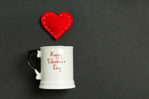 Top view composition of red hearts falling out from a cup on colorful background with copy space. Romantic relationship concept. St Valentaine's Day photo