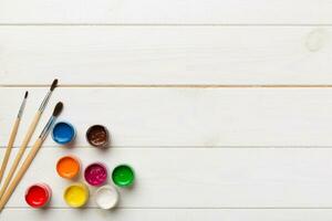 art palette with paint and brushes, close up. Top view with empty space. workplace for creativity. home teaching concept drawing photo