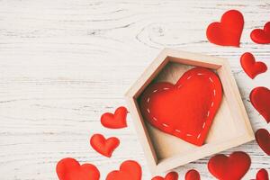 Top view of red heart in a house decorated with small hearts on wooden background. Valentine's day. Home sweet home concept photo