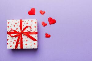 Valentine day composition red  gift box with bow and heart. Christmas present. View from above. Space for text. Holday greeting card photo