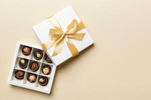 White box with chocolates candies and golden tape. top view with copy space photo