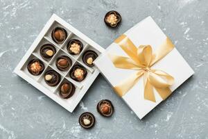 White box with chocolates candies and golden tape. top view with copy space photo