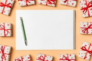 Top view of notebook surrounded with gift boxes on colorful background. Valentine's day photo