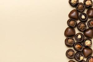 Different kinds of chocolates on colored table close-up. Top View and Flat Lay with copy space photo