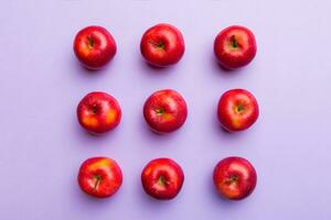 Many red apples on colored background, top view. Autumn pattern with fresh apple above view photo