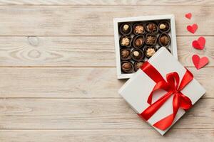 Delicious chocolate pralines in red box for Valentine's Day. Heart shaped box of chocolates top view with copy space photo