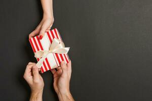 Top view of a woman and a man giving and receiving a present on colorful background. Love and relationship concept. Copy space photo