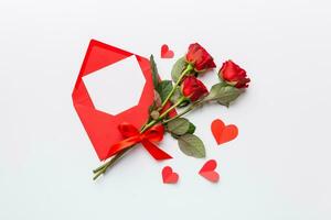 Valentine day composition with Envelope, rose flower and Red heart on table. Top view, flat lay. Holiday concept photo