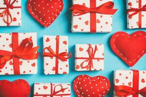 Top view of white gift boxes and red textile hearts on colorful background. Valentine's Day concept photo