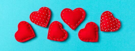 Composition of textile red hearts on colorful background with empty space for your design. Top view of St. Valentine's day concept photo