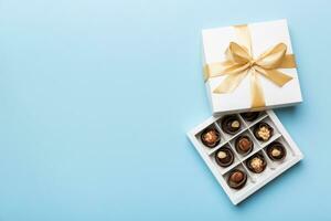 White box with chocolates candies and golden tape. top view with copy space photo