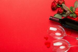 Valentine's day composition with red wine, rose flower and gift box on table. Top view, flat lay. Holiday concept photo