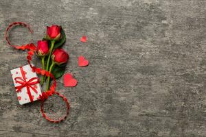 Valentine's day composition with rose flower, red heart and gift boxes on table. mother day and birthday greeting, copy space, top view photo