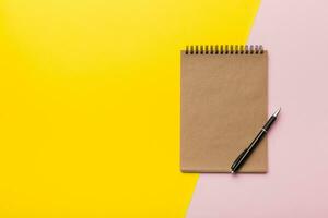 school brown notebook on a colored background, spiral craft notepad on a table Top view photo