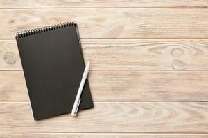 school notebook on a colored background, spiral black notepad on a table Top view photo