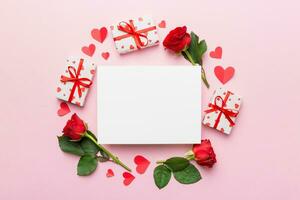 Frame made of rose, git box, heart and blank greeting card mockup on Colored background. Top view, flat lay, copy space Holiday, Mothers Day, birthday concept photo