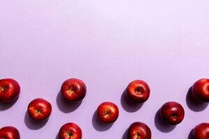 Many red apples on colored background, top view. Autumn pattern with fresh apple above view photo