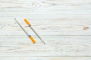 Top view of insulin syringe prepared for injection at wooden background. Diabetes concept with copy space photo