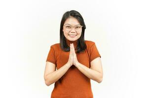 haciendo namaste saludo de hermosa mujer asiática aislada sobre fondo blanco foto