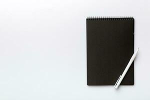 school notebook on a colored background, spiral black notepad on a table Top view photo