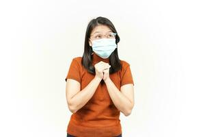 Wearing Mask Folding hand and Pray Of Beautiful Asian Woman Isolated On White Background photo