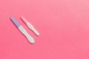 Colored Pregnancy test on colored background, top view with copy space photo