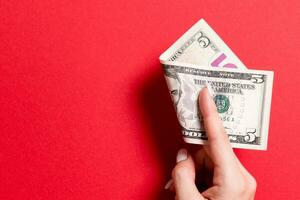 Top view of female hand holding a pack of money on colorful background. Five dollars. Business concept with empty space for your design. Charity and tips concept photo