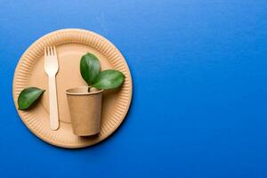 set of empty reusable disposable eco-friendly plates, cups, utensils on light white colored table background. top view. Biodegradable craft dishes. Recycling concept. Close-up photo