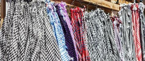 Traditional Keffiyeh or kefia hanging on hangers on bazaar in Egypt photo