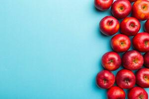Many red apples on colored background, top view. Autumn pattern with fresh apple above view with copy space for design or text photo